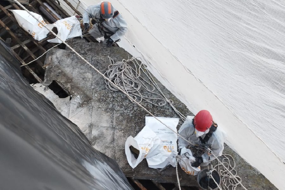 Obreros en un trabajo vertical con trajes de seguridad